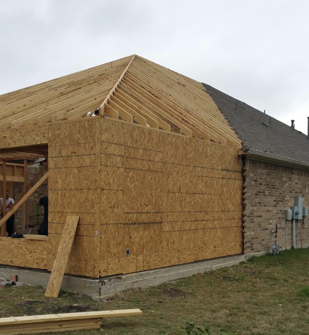 Roof trusses and rafters framed for a room addition tying into the existing roofline