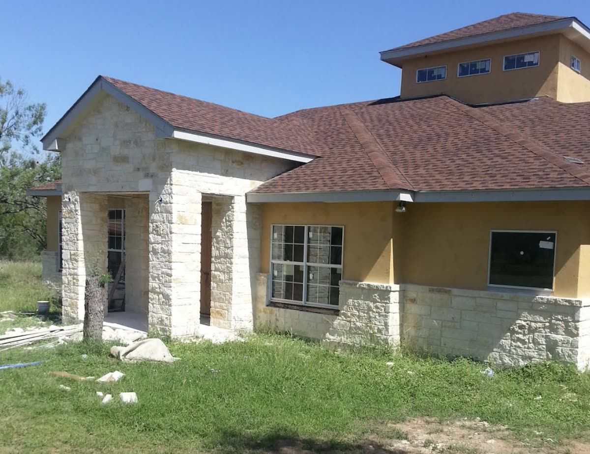 Stone-columned entry portico on a home addition under construction