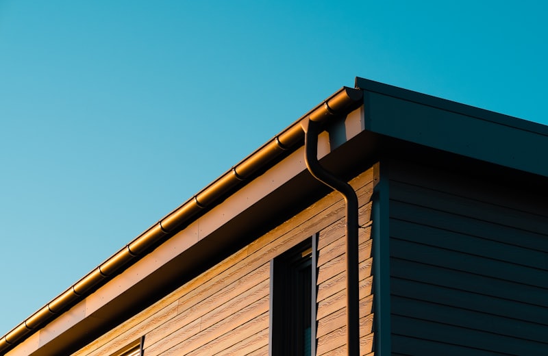 Gutter and roofline on a wood-sided home at golden hour